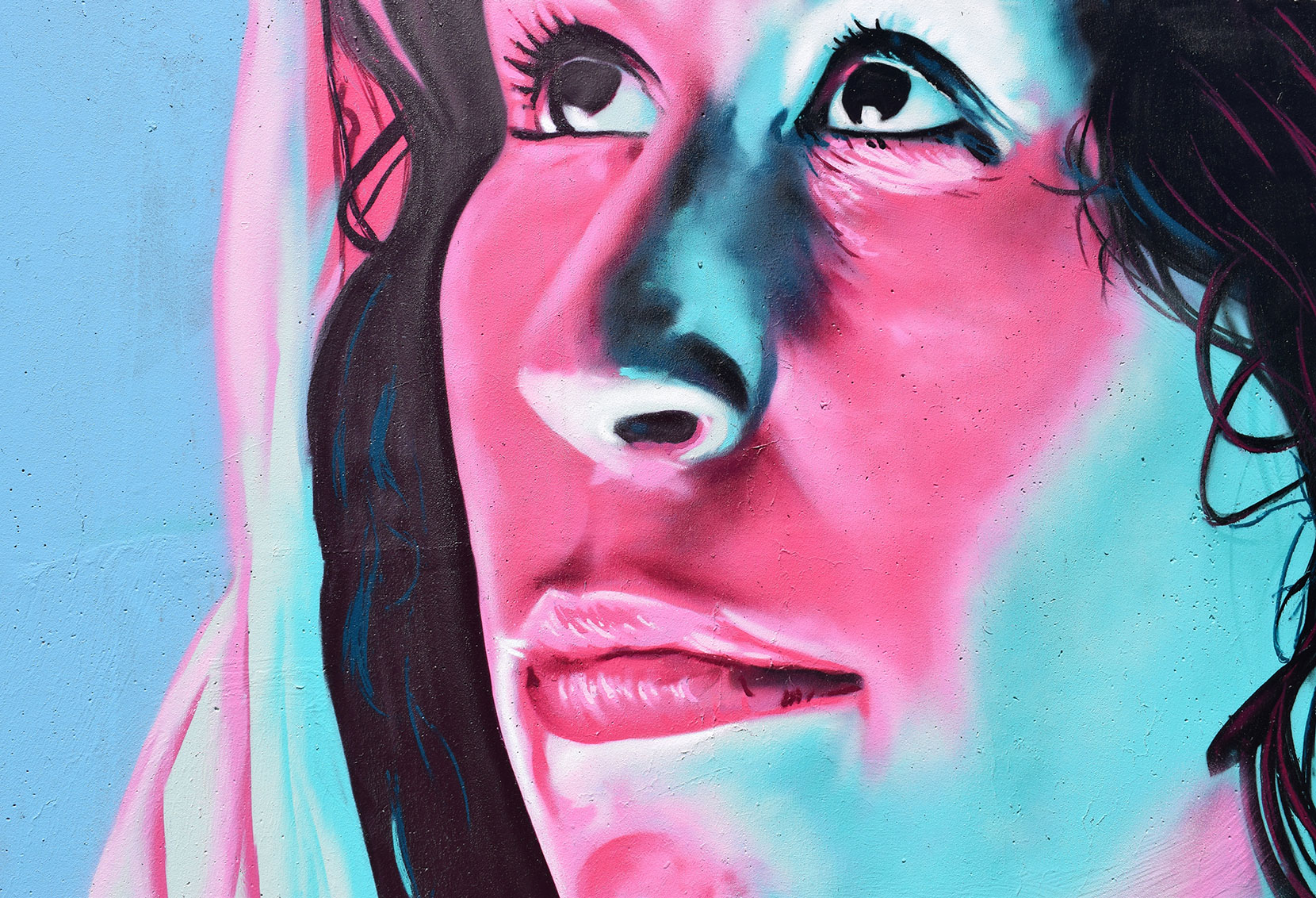 Close-up of a woman's face with vibrant pink and blue lighting.