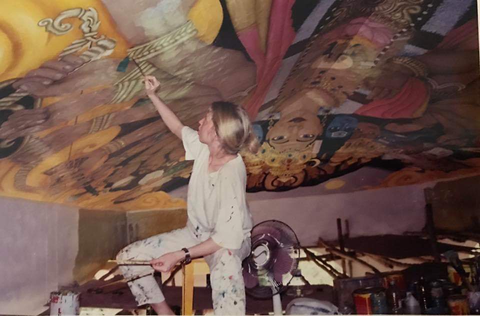 A performer onstage with a vibrant, colorful backdrop.