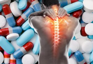 Person clutching back, highlighting spinal pain amid pills.